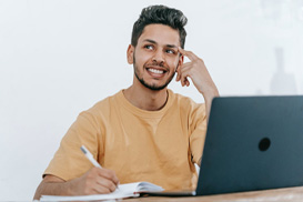 A male student thinking about what to write