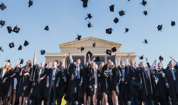 Graduates throwing their hats in the air in celebration