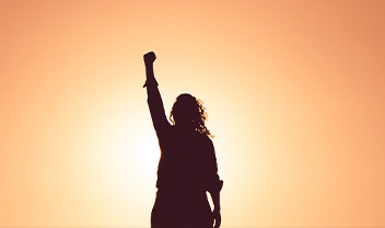 A silhouette of a lady punching the air