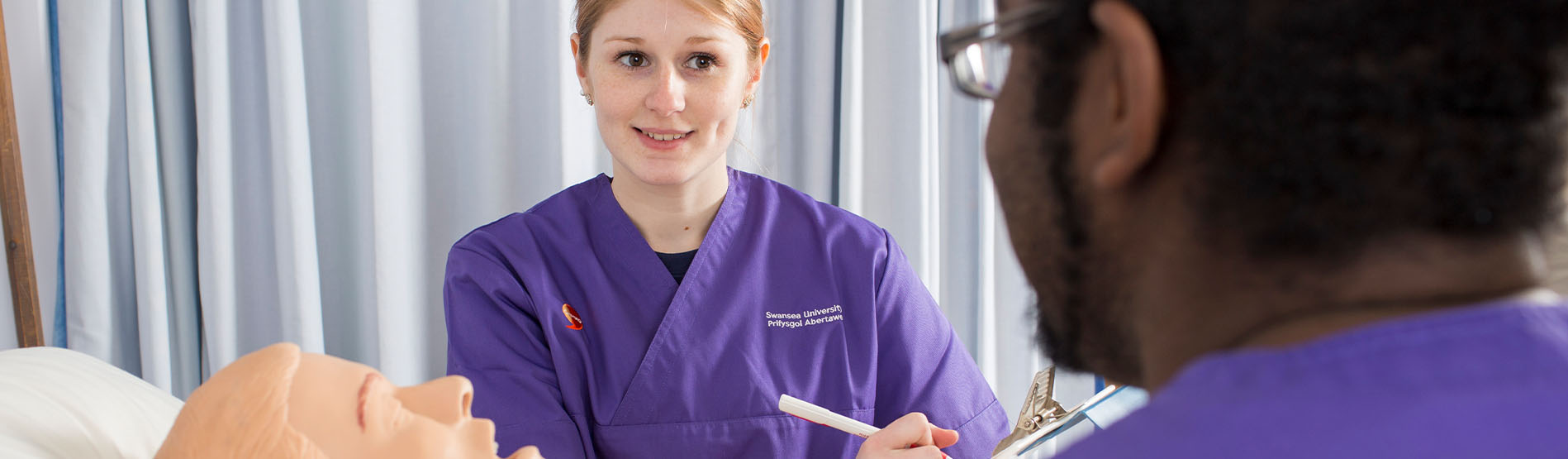 Nursing students practising skills together