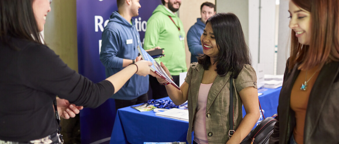 Student meeting university staff at an in person event