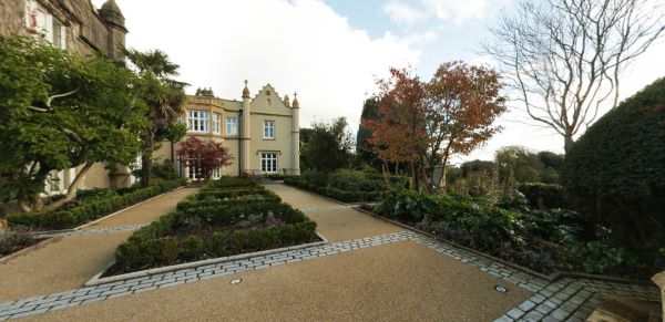 Abbey building with landscaped gardens and paths in autumn surroundings
