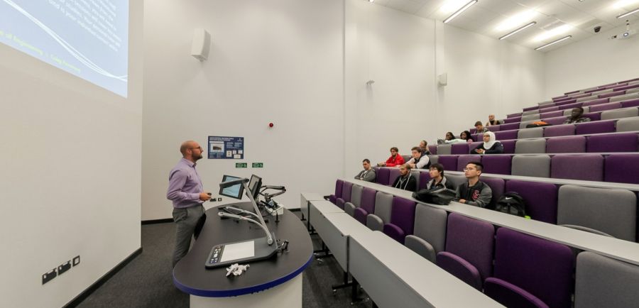 360-degree panorama of tiered lecture theatre with seating and screens