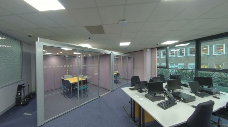 Computer lab with desktop workstations and glass meeting room