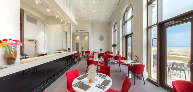 Great Hall café and restaurant with tables, red seating and sea views