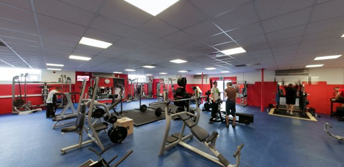 Gym with weight machines, benches, and people exercising