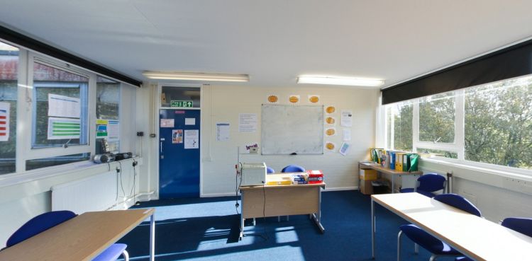 Lecture room with desks, chairs, whiteboard and teaching equipment
