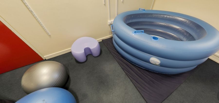 Midwifery practice suite with birthing pool, exercise balls and stool