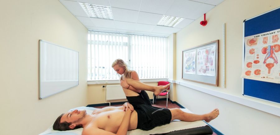 Osteopathic treatment room with leg mobility assessment on treatment table