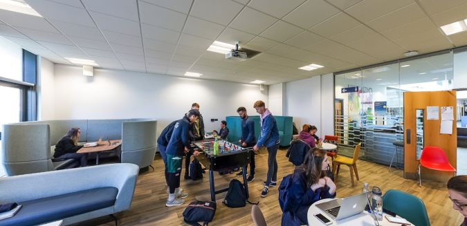 Student common room with seating areas, study booths and table football