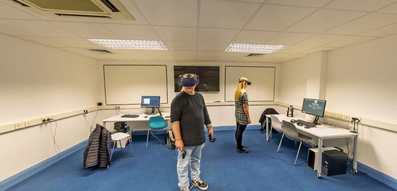 Students using virtual reality headsets in an immersive learning room